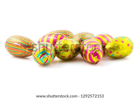 Group of easter chocolate eggs in colorful wrapping paper, white background