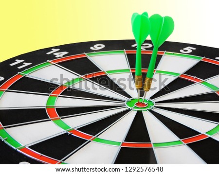  Dart arrow hitting in the target center of dartboard. Success hitting target aim goal achievement concept background.Darts and dart board.Close up shot of the dart arrow.Marketing concept.