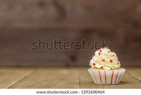 Festive cupcake on wooden background. Holidays card with empty space for text