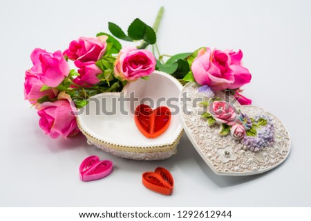 Opened heart box with mini handcraft inside with decoration bouquet of roses on white background for Happy Valentine's Day