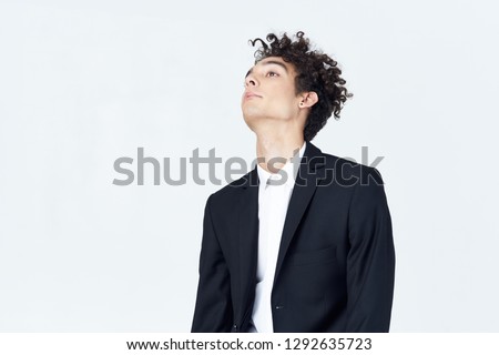 Business man in a suit on a gray background raised his head up                 
