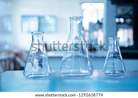 three size of glass flasks in blue university education chemistry science laboratory background
