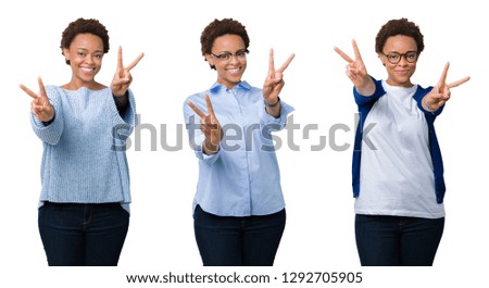 Young african american woman with afro hair over isolated background smiling looking to the camera showing fingers doing victory sign. Number two.
