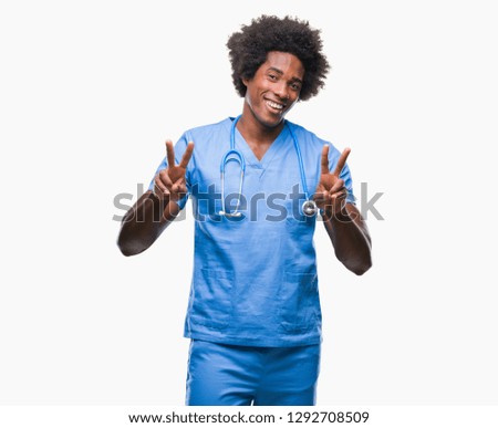 Afro american surgeon doctor man over isolated background smiling looking to the camera showing fingers doing victory sign. Number two.