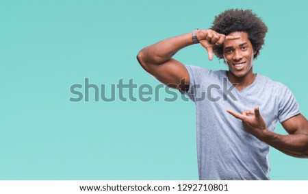 Afro american man over isolated background smiling making frame with hands and fingers with happy face. Creativity and photography concept.