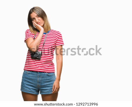 Young beautiful woman taking pictures using vintage photo camera over isolated background thinking looking tired and bored with depression problems with crossed arms.