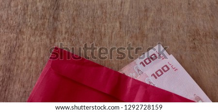 Money and red paper envelopes on the wooden floor.