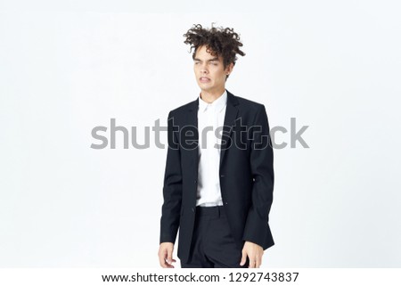 Cute business man in a suit stands in full growth on a light background