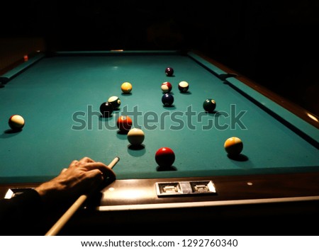 Men playing snooker,The player is aiming to shoot the snooker ball,Hands on a green snooker table 