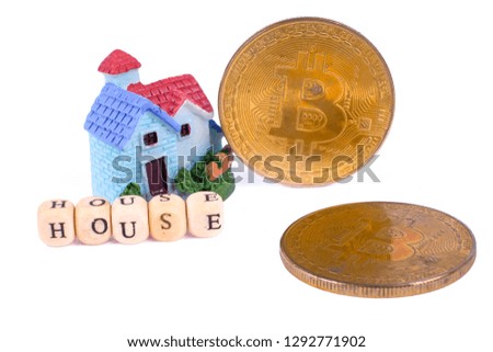 Bit coins and HOUSE words in front of house model isolated on white backrgound