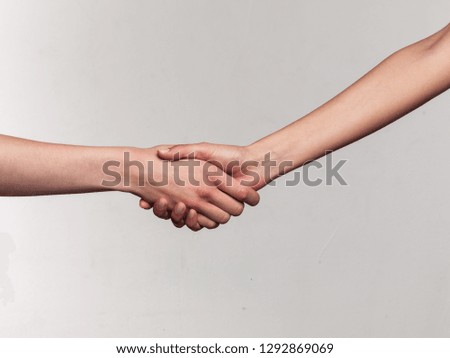 Two female hands on gray background in studio with soft light