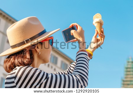 The girl takes pictures of ice cream on her smartphone