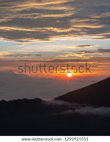 Beautiful and Magnificent Sunrise at Mount Batur, A live volcanic mountain, Orange glow in the sky with silhouette of mountains
