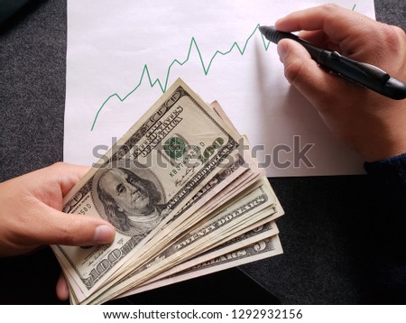 graphic with ascending line, ballpoint pen, business man hands and american banknotes