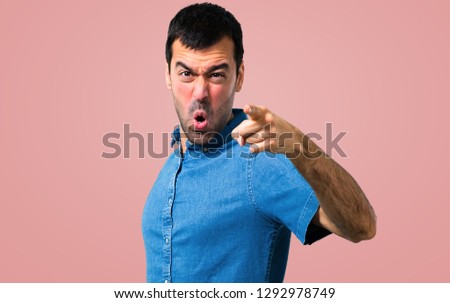 Handsome man with blue shirt  annoyed and angry in furious gesture on pink background