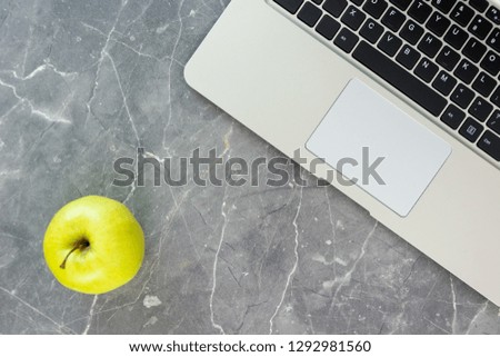 green apple and laptop on table