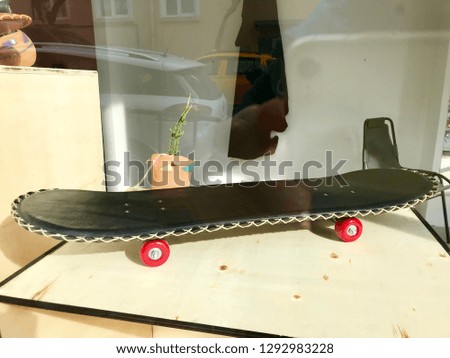 Skateboard made of black leather stands on skate table.