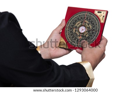 Feng Shui Master show FengShui Compass and turn direction to Force Energy, Chinese Texts on Compass mean translate as North South West East Luck Prosperity on Wind Water elements Flow, isolated Royalty-Free Stock Photo #1293064000