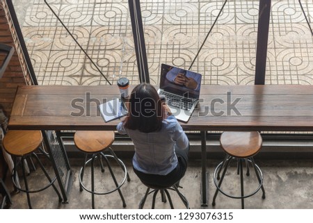 Rear view photo of Asian businesswoman checking email on phone