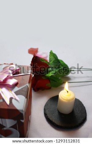 Photoshoot of rose, gift boxes, and candle burning. Valentine day