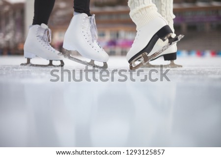 Closeup skating shoes ice skating outdoor at ice rink. Small glitter at the ice. Healthy lifestyle and winter sport concept at sports stadium. Large copy space at foreground