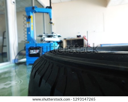 The tire on the floor has a tire changer on the back