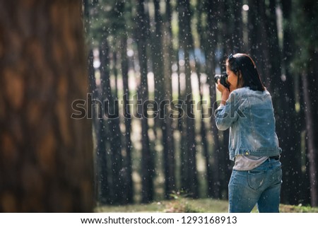 female photographer at pine tree forest in rainy season, travel concept