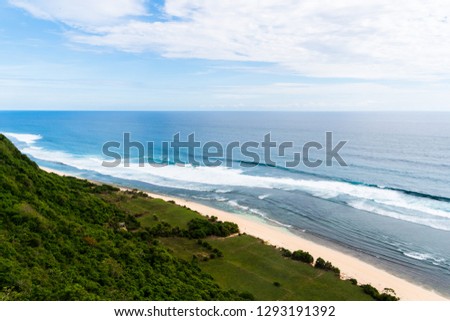 Bali seascape with huge waves at beautiful hidden white sand beach. Bali sea beach nature, outdoor Indonesia. Bali island landscape. Summer holidays at ocean beach. Travel vacation in Indonesia beach.