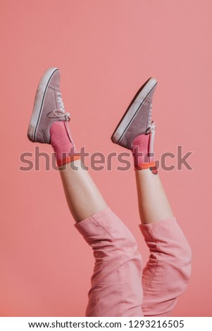 Woman legs in pink pants up in the air Royalty-Free Stock Photo #1293216505
