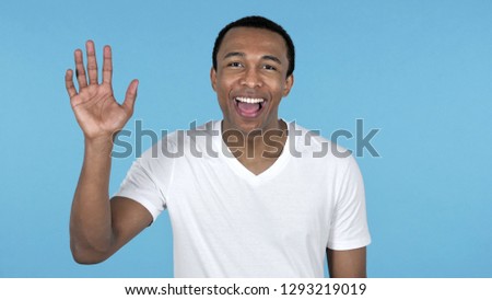 African Man Waving Hand to Welcome Isolated on Blue Background