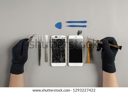 Technician prepairing to repair and replace new screen broken and cracked screen smartphone prepairing on desk Royalty-Free Stock Photo #1293227422