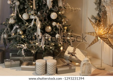 christmas silver gift boxes with garlandas lights on background