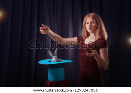 girl shows focus with a rabbit in a hat