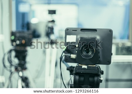 Lens of a film camera in an television broadcasting studio, spotlights and equipment