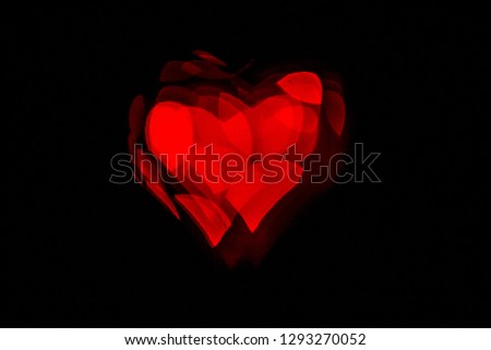 Red hearth ballon light on a black background. Valentine's day picture with vibrant colors