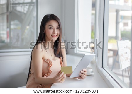 Young asian woman holding credit card and using laptop. Online shopping concept.