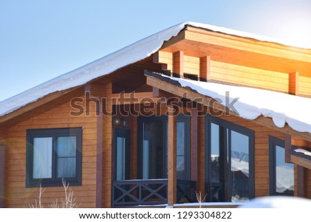 Part of the facade of a wooden house in modern style and sun rays. Natural photo.