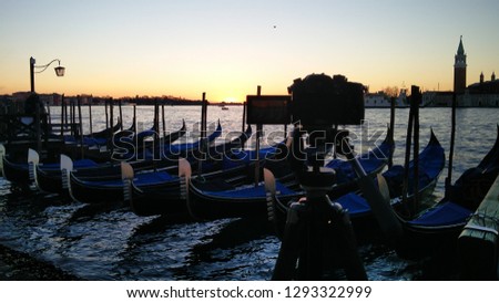 Photo Camera Taking a picture of Venice Sunrise with nobody, Black Gondola and Golden Sun Light over the Grand Canal