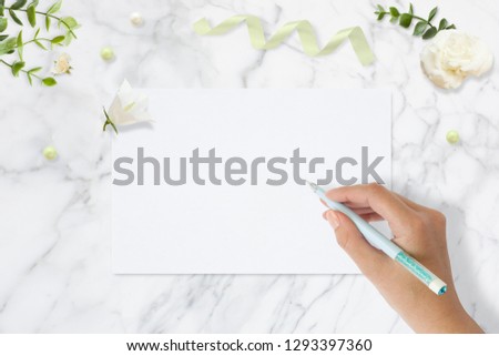 Styled stock photo. Feminine wedding desktop mockup. Greeting card. Flowers, paper, pen, tape on delicate marble background. Copy space. Top view. Picture for blog