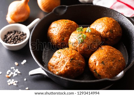 Food Homemade raw organic spicy meatball in iron cast on black background
