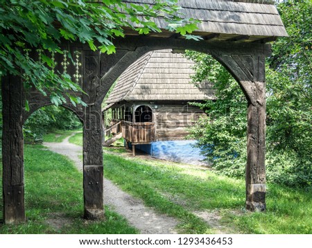 Old village in Maramures, Romanian traditional architectural style. Traditional carved wooden gate with wooden house in an old village in Transylvania. Rural scene in Romania. Royalty-Free Stock Photo #1293436453