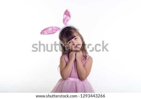 Cute kid dressed as the Easter bunny standing on white background and celebrating. Child Easter Holiday Concept.