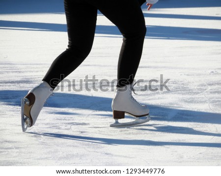Ice skating, girl in the skates. Female legs at the rink, winter sports and fun
