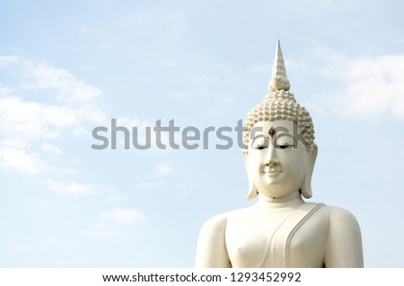 White Buddha statue on sky and cloud background.