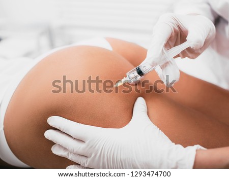 Beautician doing Injection into female buttocks, body mesotherapy Royalty-Free Stock Photo #1293474700