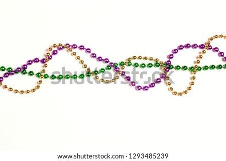 Mardi Gras three colours beads on white background. Space for text.