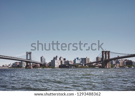 Brooklyn Borough seen between two famous New York bridges, Manhattan Bridge and Brooklyn Bridge, retro color toned picture, USA.