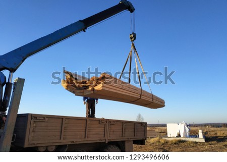 load boards supplied to the construction site with a crane, manipulator Royalty-Free Stock Photo #1293496606