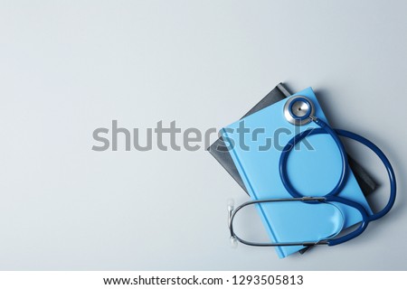 Student textbooks, stethoscope and space for text on grey background. Medical education Royalty-Free Stock Photo #1293505813