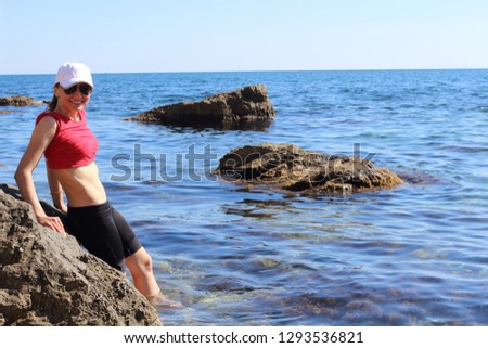 Wonderful landscape with a beautiful girl on the Crimean coast of the Black Sea. A young and long-legged girl with luxurious hair is resting in nature